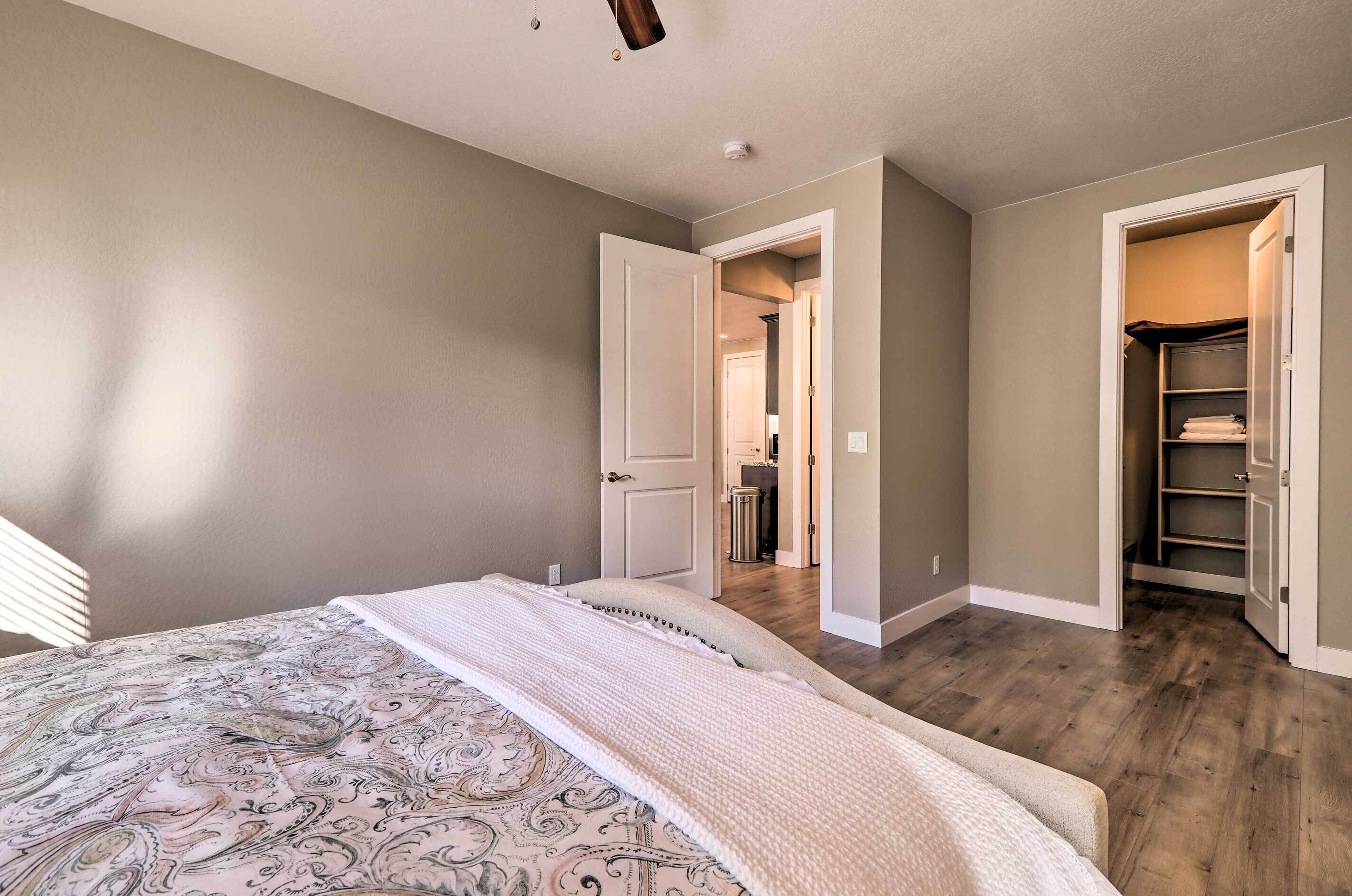 Quarto com cama, closet espaçoso e corredor que dá para outro cômodo.