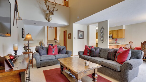 A spacious living room with two grey sofas, a wooden coffee table, and a red rug. - Eclectic Eagle-vail Condo: 2 Miles to Beaver Creek (Avon)