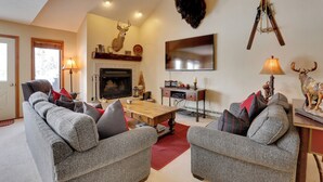 A cozy living room with a fireplace, a mounted deer head, and a mounted elk head. - Eclectic Eagle-vail Condo: 2 Miles to Beaver Creek (Avon)
