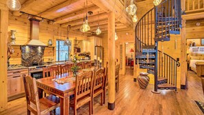 A wooden interior with a dining area, kitchen, and a spiral staircase. - Luxury Mountain Cabin w/ Furnished Deck + Views! (Mount Lemmon)