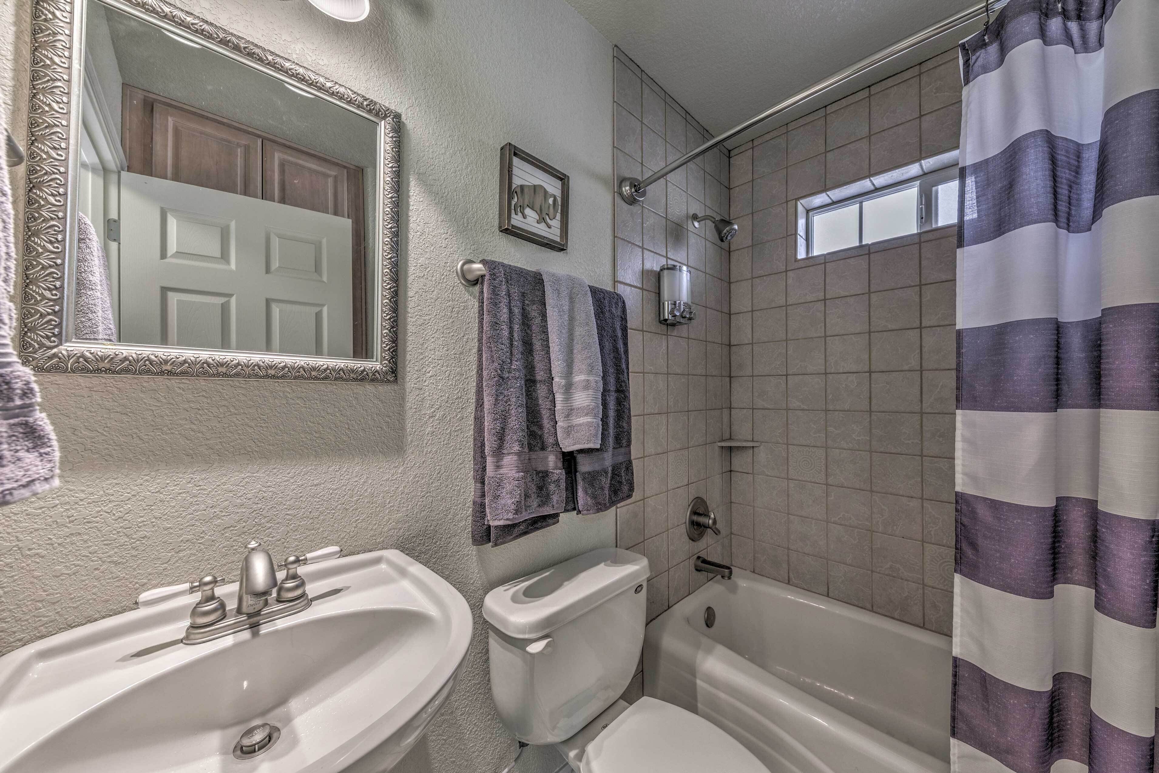 Un baño con lavamanos, inodoro y ducha.