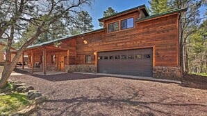 A log cabin with a stone foundation, a covered porch, and a garage. - 2 Decks & Game Room: Expansive Family Cabin (Pinetop)