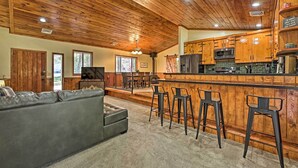 A spacious living room with a grey sofa and a wooden ceiling. - 2 Decks & Game Room: Expansive Family Cabin (Pinetop)