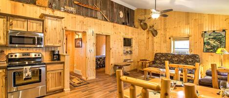 Un intérieur rustique en bois comprenant une cuisine, un coin repas et un espace détente.