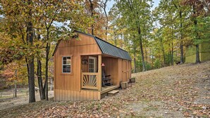 A small wooden cabin with a porch, surrounded by trees with autumn foliage. - 1 Mi to Raystown Lake: Bill Pickett Ranch Apt (Huntingdon)