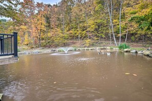 A pond with a fountain, surrounded by autumn-colored trees and a wooden deck. - 1 Mi to Raystown Lake: Bill Pickett Ranch Apt (Huntingdon)