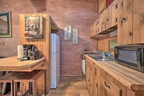 A kitchen with wooden cabinets, a refrigerator, a microwave, and a sink. - 1 Mi to Raystown Lake: Bill Pickett Ranch Apt (Huntingdon)