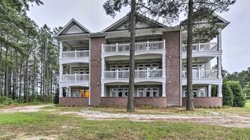 A multi-story building with a brick facade and white balconies.