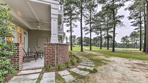 A house with a covered porch, a brick column, and a pathway leading to a grassy area with trees. - Anderson Creek Resort Condo on Golf Course w/ Pool (Spring Lake)