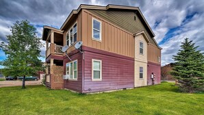 A two-story house with a balcony, a satellite dish, and a well-maintained lawn. - Walk to Main St! Ennis Townhome w/ Balcony (Ennis)