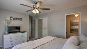 A bedroom with a bed, a dresser, a television, a ceiling fan, and a door leading to another room. - Dock & Grand Lake Access! Idyllic Afton Getaway (Afton)