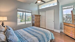 Une chambre à coucher avec un lit, un ventilateur de plafond, une commode et une fenêtre.