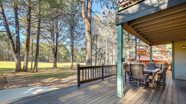 A wooden deck with outdoor seating and a view of a golf course. - 4 Mi to Woodland Lake: 2-story Home w/ Grill (Pinetop)