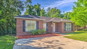 A two-story brick house with a front porch, a driveway, and a well-maintained lawn. - Home 10 Mi to Downtown Pensacola: Pets Welcome! (Pensacola)