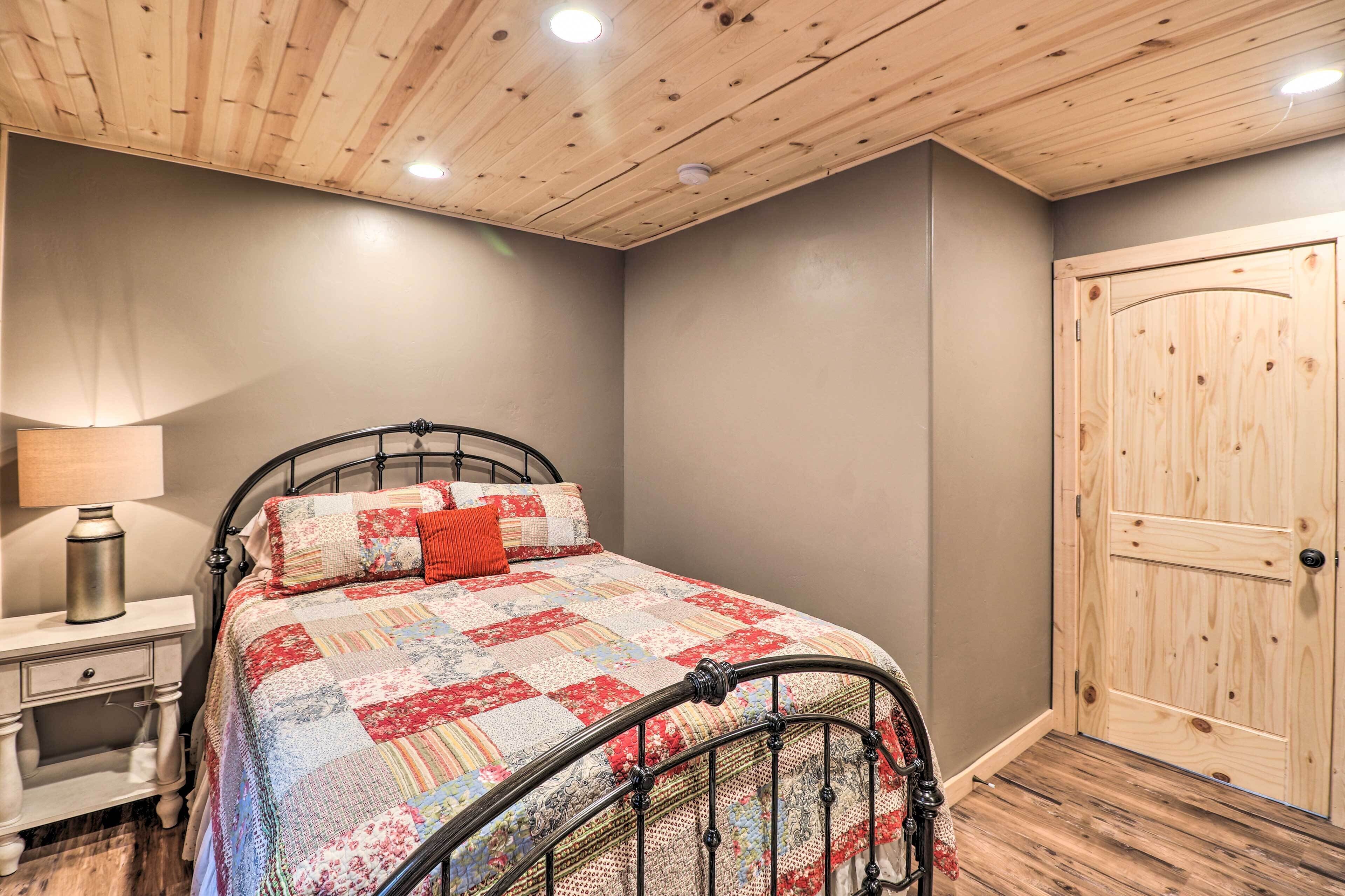 Une chambre à coucher avec un lit en métal, une couvre-lit matelassée, une porte en bois et une table de chevet avec une lampe.