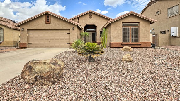 A residential building with a garage, a front entrance, and a landscaped driveway with pebbles and cacti. - Bbq-ready Oasis Near Golfing + Surprise Stadium! (Surprise)