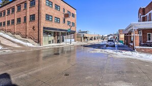 A brick building with a storefront, a staircase leading up to the entrance, and a clear sky. - Beauty in the Black Hills: An Upscale Apt. in Lead (Lead)