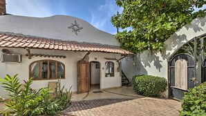 A courtyard with a tiled roof, a wooden door, and a black gate. - Sayulita Condo: Walk to Beach, Plaza & Dining! (Sayulita)