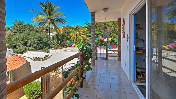 A balcony with a view of palm trees and a tiled floor. - Sayulita Condo: Walk to Beach, Plaza & Dining! (Sayulita)