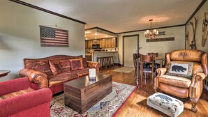 A living room with a sofa, armchair, and ottoman, a wooden coffee table, and a rug. - Brian Head Condo w/ Patio & Community Amenities! (Brian Head)
