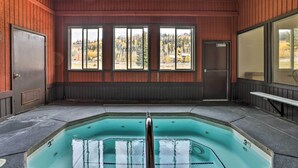 A hot tub with a view of a forested area through large windows. - Brian Head Condo w/ Patio & Community Amenities! (Brian Head)