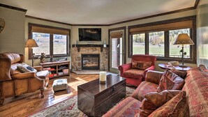 A cozy living room with a fireplace, leather sofas, and a stone accent wall. - Brian Head Condo w/ Patio & Community Amenities! (Brian Head)