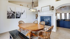 A dining area with a wooden table and chairs, a chandelier, and wall art. - Flagstaff Home w/ Hot Tub & Mountain Views (Flagstaff)