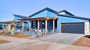 A modern two-story house with a blue exterior, a covered porch, and a garage. - Flagstaff Home w/ Patios + Mount Humphries Views! (Flagstaff)
