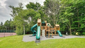 A playground with slides and climbing structures surrounded by trees. - Bromley Mountain Escape w/ 2 Balconies: Hike & Ski (Peru)