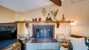 A living room with a fireplace, a television, and a lamp. - Bromley Mountain Escape w/ 2 Balconies: Hike & Ski (Peru)