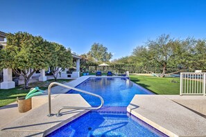 A rectangular swimming pool with a metal ladder, surrounded by a well-maintained lawn and trees. - Lavish Paradise Valley Home w/ Sports Court & Pool (Paradise Valley)