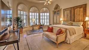 A spacious bedroom with a large bed, a wooden headboard, and a ceiling fan. - Lavish Paradise Valley Home w/ Sports Court & Pool (Paradise Valley)