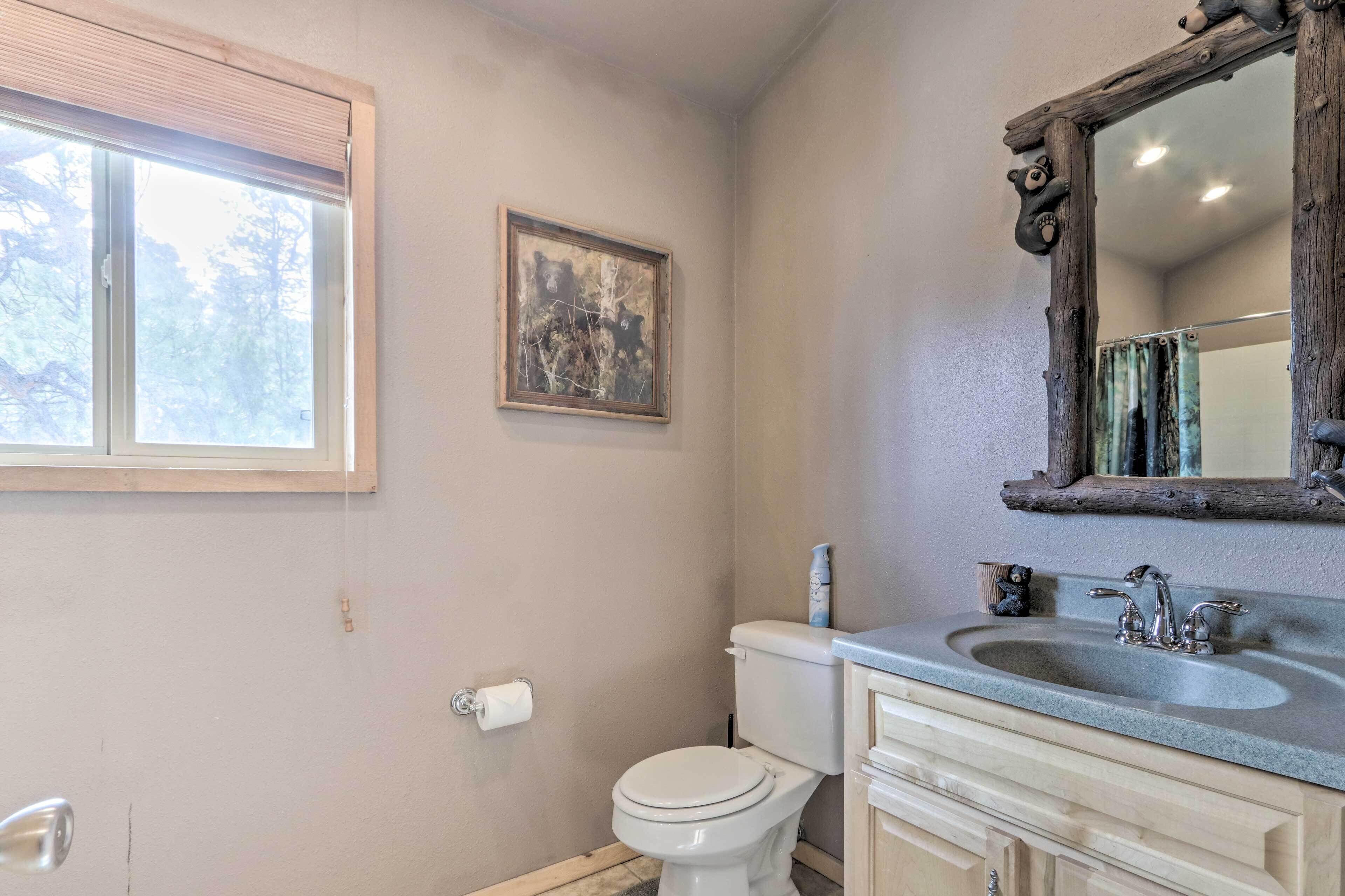 Een badkamer met toilet, wastafel en raam.