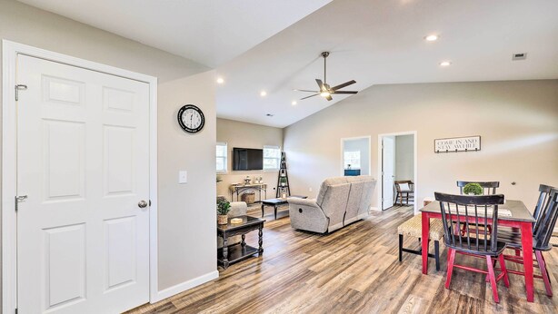 A spacious living area with a dining table, chairs, and a sofa.