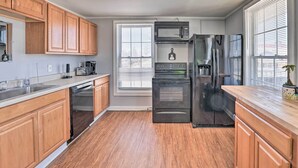 A modern kitchen with wooden cabinets, a stainless steel refrigerator, a built-in oven, and a microwave. - Downtown Canandaigua Apt: 1 Mi to Lake & Pier! (Canandaigua)