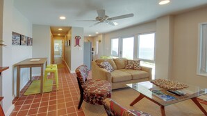 A living room with a sofa, chairs, a coffee table, and a dining area with a table and chairs. - 'sea La Vie' - Waterfront St Thomas Escape w/ Pool (St. Thomas)