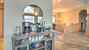A modern kitchen with a coffee station, a large mirror, and a view of the hallway. - Dock, Hot Tub & Game Room: Luxe Lake Latoka Home (Alexandria)