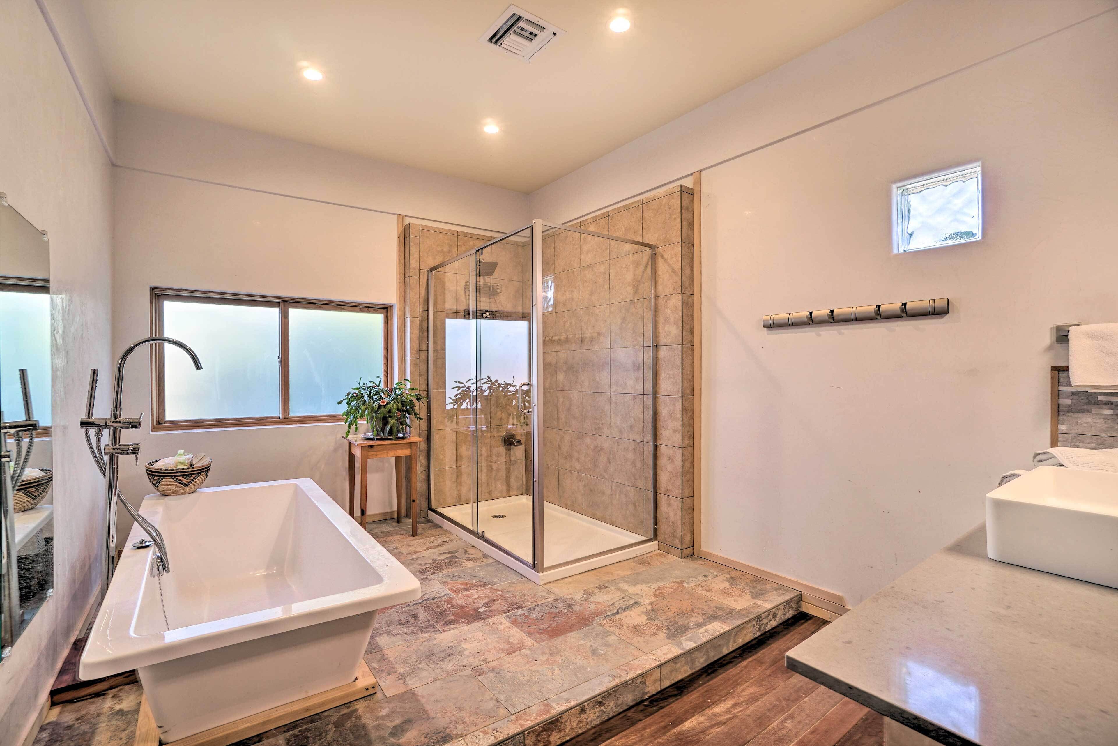A modern bathroom with a freestanding bathtub, a glass-enclosed shower, and a vanity with a sink.