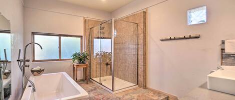 A modern bathroom with a freestanding bathtub, a glass-enclosed shower, and a vanity with a sink.