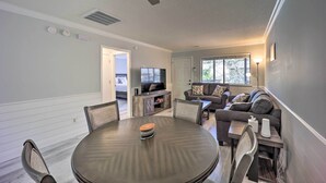 A dining area with a round table, chairs, and a television in the background. - Updated Wilmington Retreat ~ 2 Miles to Uncw! (Wilmington)