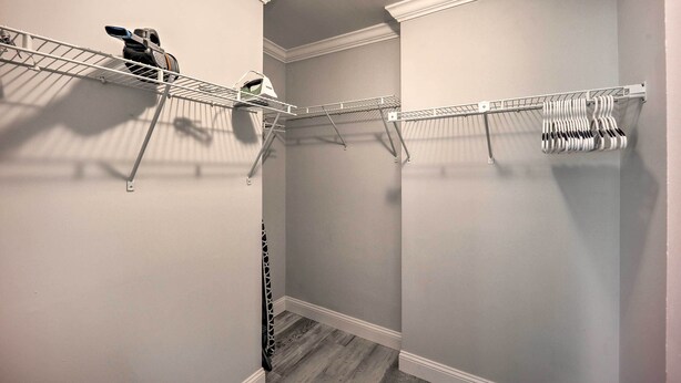 A walk-in closet with two metal drying racks, one with hanging clothes and the other with folded clothes. - Updated Wilmington Retreat ~ 2 Miles to Uncw! (Wilmington)