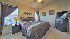 A bedroom with a bed, nightstands, a dresser, a ceiling fan, and artwork on the walls. - 2 Mi to Goodyear Ballpark! Home w/ Poolside Oasis (Goodyear)