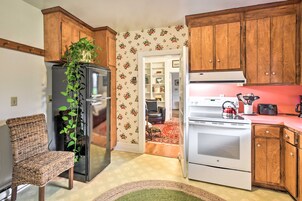 Una cocina compacta con gabinetes de madera, un refrigerador, un horno y un microondas.