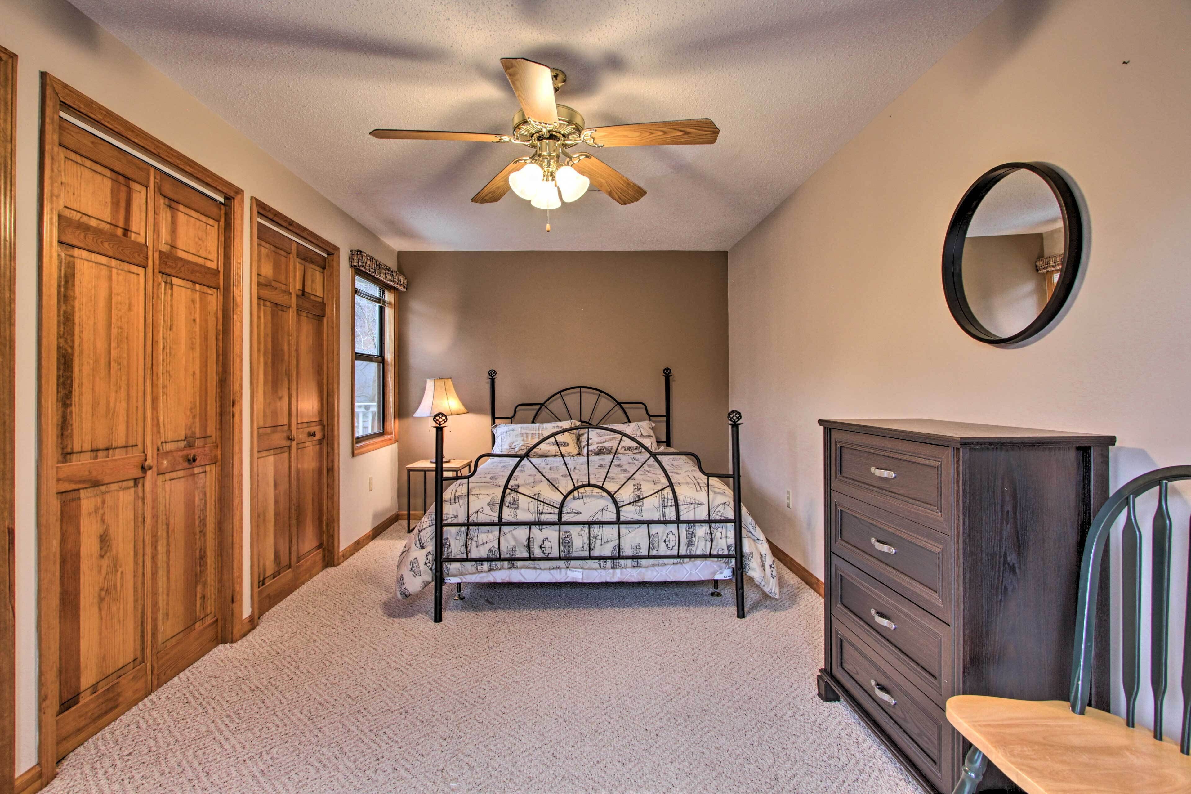 A bedroom with a bed, dresser, and wardrobe.