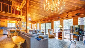 A spacious living area with a large sectional sofa, a wooden dining table, and a chandelier. - Waterfront Truckee Cabin on Donner Lake! (Truckee)