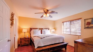 A bedroom with a wooden bed, bedside lamps, a ceiling fan, and a window with blinds. - 2 Mi to Whiskey Row: Tranquil Getaway w/ Deck! (Prescott)