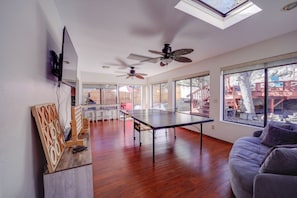 A spacious living area with a ping pong table, ceiling fans, and large windows offering views of the outdoors. - 2 Mi to Whiskey Row: Tranquil Getaway w/ Deck! (Prescott)