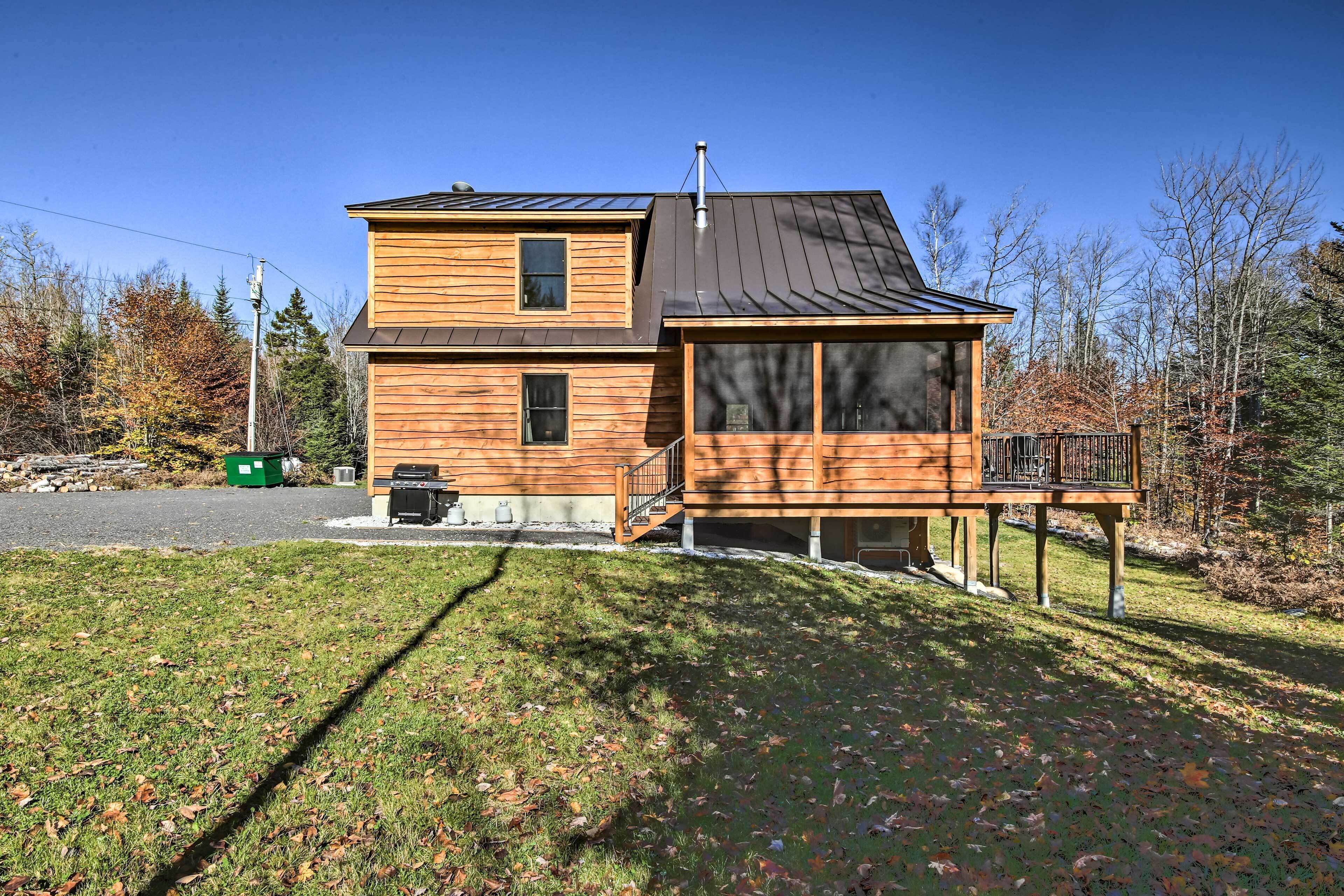 A two-story wooden house with a balcony, a chimney, and a garage.