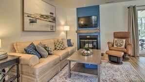 A living room with a sofa, coffee table, and a fireplace.