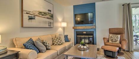 A living room with a sofa, coffee table, and a fireplace.